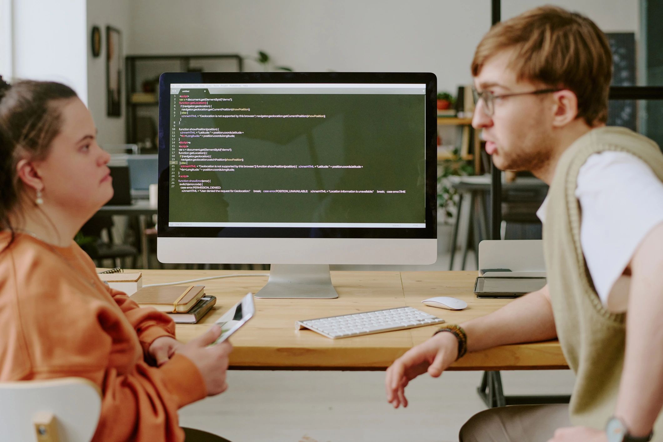 Two indie developers collaborating at a workstation